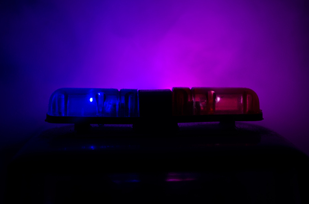 Red light flasher atop of a police car. City lights on the background.の写真素材