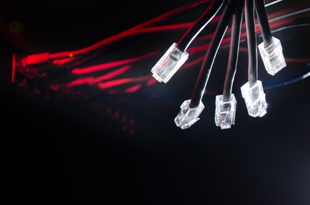 Network switch and ethernet cables, symbol of global communications. Colored network cables on dark background with lights and smoke. Selective focus. Network internet concept backgroundの写真素材