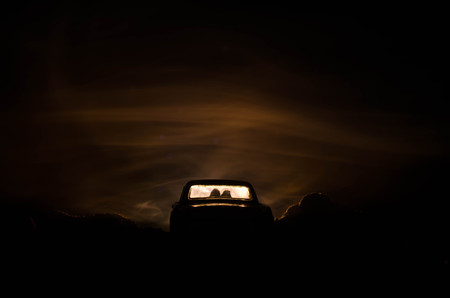 silhouette of car with couple inside on dark background with lights and smoke. Romantic sceneの写真素材