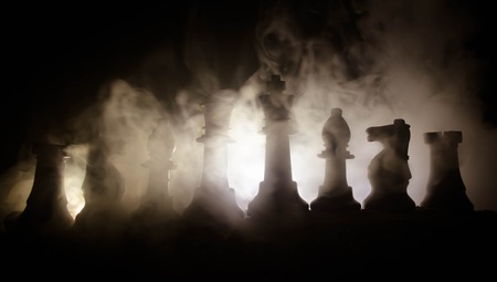 chess board game concept of business ideas and competition and strategy ideas concep. Chess figures on a dark background with smoke and fog. Selective focusの写真素材
