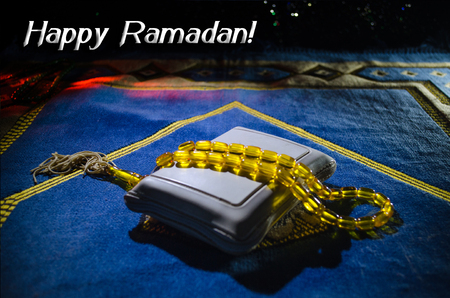 Holy Quran with beads on a prayer mat, Muslim Tasbih is a string of prayer beads which is traditionally used by Muslims along with the Quran. Ramadan holidays concept. Selective focusの写真素材