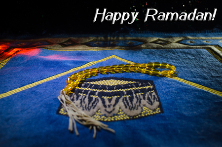 Holy Quran with beads on a prayer mat, Muslim Tasbih is a string of prayer beads which is traditionally used by Muslims along with the Quran. Ramadan holidays concept. Selective focusの写真素材