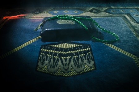 Holy Quran with beads on a prayer mat, Muslim Tasbih is a string of prayer beads which is...