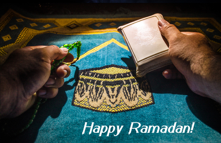 Holy Quran with beads on a prayer mat, Muslim Tasbih is a string of prayer beads which is traditionally used by Muslims along with the Quran. Ramadan holidays concept. Selective focusの写真素材