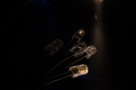 Network switch and ethernet cables, symbol of global communications. Colored network cables on dark background with lights and smoke. Selective focus. Network internet concept backgroundの写真素材