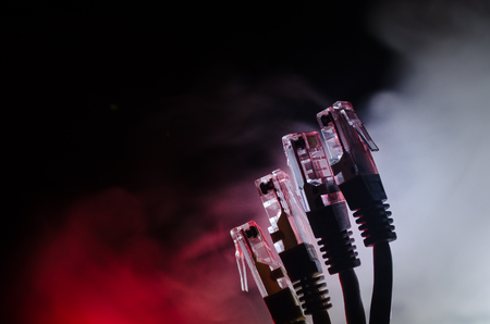 Network switch and ethernet cables, symbol of global communications. Colored network cables on dark...