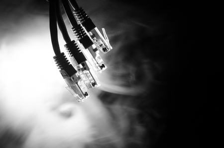 Network switch and ethernet cables, symbol of global communications. Colored network cables on dark background with lights and smoke. Selective focus. Network internet concept backgroundの写真素材