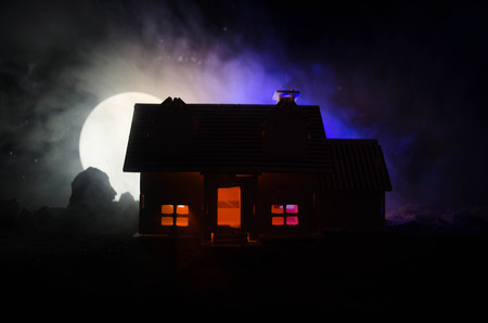 Old house with a Ghost in the moonlit night or Abandoned Haunted Horror House in fog. Old mystic villa with surreal big full moon. Horror Halloween concept.の写真素材