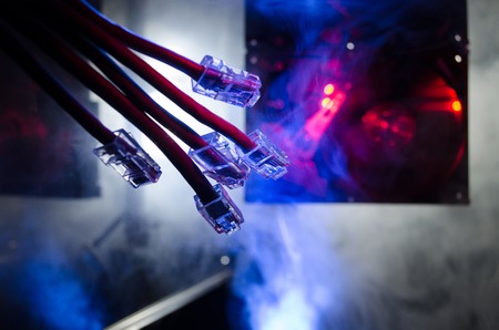 Network switch and ethernet cables, symbol of global communications. Colored network cables on dark...