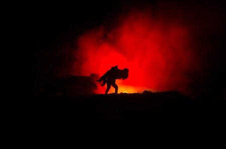 a silhouette of a man holding on to the woman. Rescue saviour concept. Escape from fire or danger. Surreal decorationの写真素材