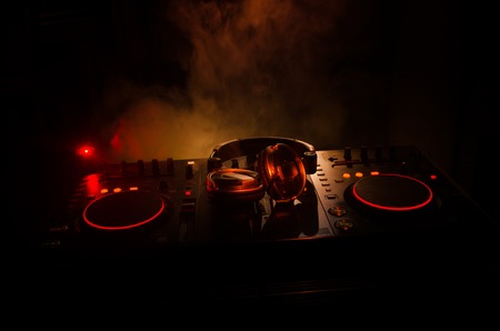 DJ Spinning, Mixing, and Scratching in a Night Club, Hands of dj tweak various track controls on...