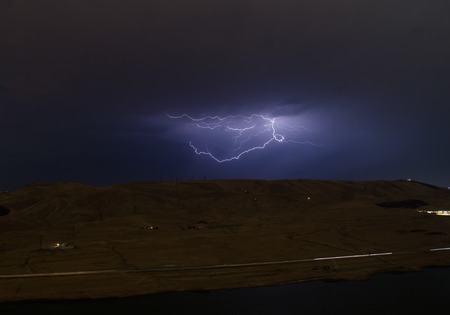 Lightning with dramatic clouds. Night thunder-storm over the mountain and the lake in Baku, Azerbaijan (Natural photo)の写真素材