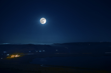 mountain river with stones and grass in the forest at the foot of mountain slope at night in moon light. Azerbaijan natureの写真素材