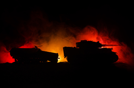 War Concept. Military silhouettes fighting scene on war fog sky background, German tank in action Below Cloudy Skyline At night. Attack scene. Armored vehicles. Tanks battle.の写真素材