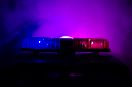 Red light flasher atop of a police car. City lights on the background.の写真素材