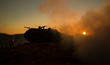 War Concept. Military silhouettes fighting scene on war fog sky background, World War Soldiers Silhouettes Below Cloudy Skyline at sunset. Attack scene. Armored vehicles. German tank in actionの写真素材