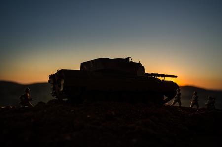 War Concept. Military silhouettes fighting scene on war fog sky background, World War Soldiers Silhouettes Below Cloudy Skyline at sunset. Attack scene. Armored vehicles. German tank in actionの写真素材