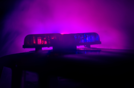 Red light flasher atop of a police car. City lights on the background.の写真素材