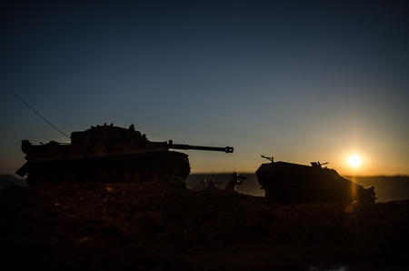 War Concept. Military silhouettes fighting scene on war fog sky background, World War Soldiers Silhouettes Below Cloudy Skyline at sunset. Attack scene. Armored vehicles. German tank in actionの写真素材
