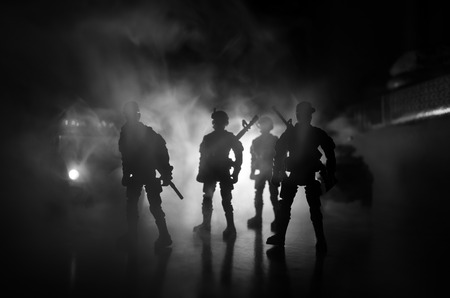 Anti-riot police give signal to be ready. Government power concept. Police in action. Smoke on a dark background with lights. Blue red flashing sirens. Dictatorship power. Selective focusの写真素材