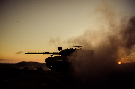 War Concept. Military silhouettes fighting scene on war fog sky background, World War Soldiers Silhouettes Below Cloudy Skyline at sunset. Attack scene. Armored vehicles. German tank in actionの写真素材