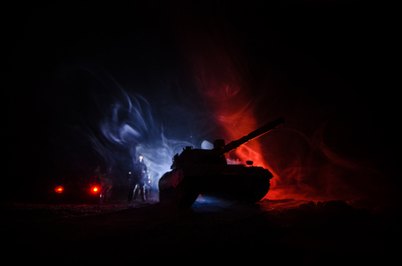 War Concept. Military silhouettes fighting scene on war fog sky background, German tank in action Below Cloudy Skyline At night. Attack scene. Armored vehicles. Tanks battle.の写真素材