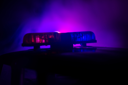 Red light flasher atop of a police car. City lights on the background.の写真素材