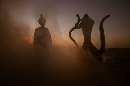 Silhouette of Arab man stands alone in the desert and watching the sunset with clouds of fogの写真素材