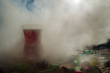 Turkish Azerbaijan tea in traditional glasse and pot outdoor nature background with sunlight and smoke. Eastern tea concept. Armudu traditional cup. Sunset timeの写真素材
