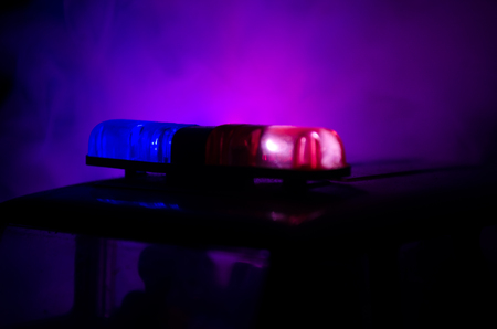 Red light flasher atop of a police car. City lights on the background.の写真素材