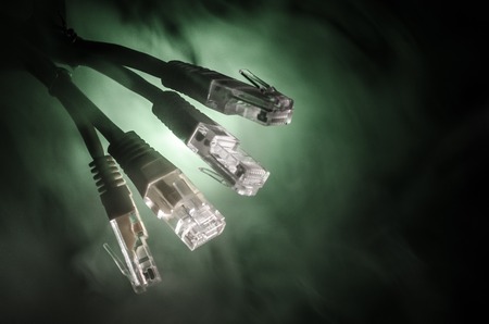 Network switch and ethernet cables, symbol of global communications. Colored network cables on dark...