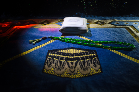 Holy Quran with beads on a prayer mat, Muslim Tasbih is a string of prayer beads which is traditionally used by Muslims along with the Quran. Ramadan holidays concept. Selective focusの写真素材
