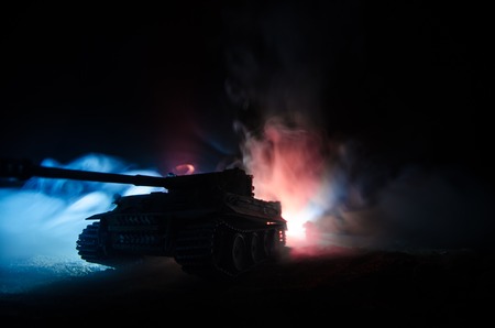 War Concept. Military silhouettes fighting scene on war fog sky background, German tank in action Below Cloudy Skyline At night. Attack scene. Armored vehicles. Tanks battle.の写真素材