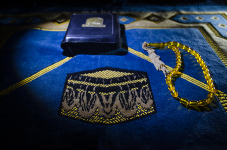 Holy Quran with beads on a prayer mat, Muslim Tasbih is a string of prayer beads which is traditionally used by Muslims along with the Quran. Ramadan holidays concept. Selective focusの写真素材