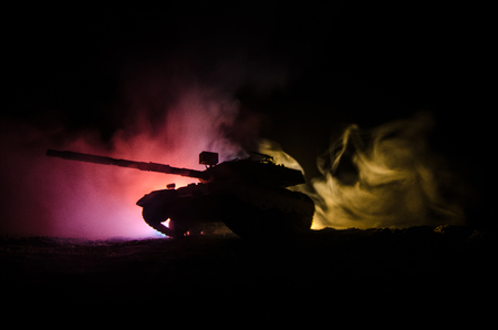 War Concept. Military silhouettes fighting scene on war fog sky background, German tank in action Below Cloudy Skyline At night. Attack scene. Armored vehicles. Tanks battle.の写真素材