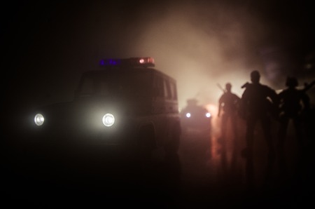 Anti-riot police give signal to be ready. Government power concept. Police in action. Smoke on a dark background with lights. Blue red flashing sirens. Dictatorship power. Selective focusの写真素材
