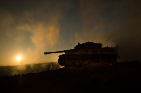 War Concept. Military silhouettes fighting scene on war fog sky background, World War Soldiers Silhouettes Below Cloudy Skyline at sunset. Attack scene. Armored vehicles. German tank in actionの写真素材