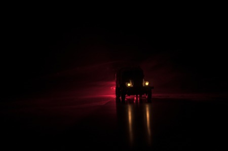 Truck in the conflict zone. The war in the countryside. War vehicle silhouette at night. Battle scene. War conceptの写真素材