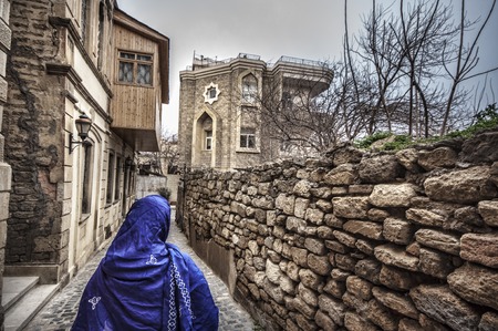 Muslim traditional woman visiting old historical city in Baku Azerbaijan. Innrer city Tonedの写真素材