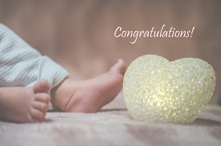 Newborn baby feet in bed close up. Happy Family concept. Beautiful conceptual image of Maternity. Useful as greeting card. Selective focusの写真素材