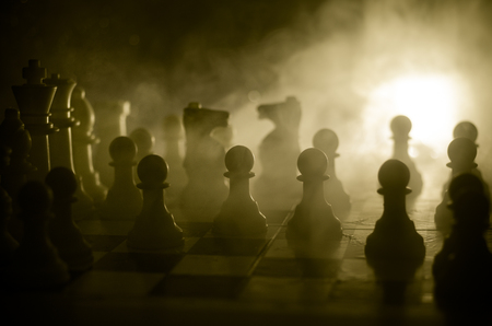 Chess board game concept of business ideas and competition and strategy ideas concep. Chess figures on a dark background with smoke and fog. Selective focusの写真素材