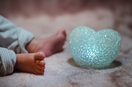 Newborn baby feet in bed close up. Happy Family concept. Beautiful conceptual image of Maternity. Useful as greeting card. Selective focusの写真素材