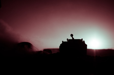 War Concept. Military silhouettes fighting scene on war fog sky background, World War Soldiers Silhouettes Below Cloudy Skyline at sunset. Attack scene. Armored vehicles. German tank in actionの写真素材