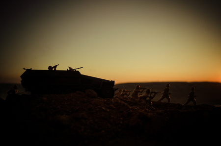 War Concept. Military silhouettes fighting scene on war fog sky background, World War Soldiers Silhouettes Below Cloudy Skyline at sunset. Attack scene. Armored vehicles. German tank in actionの写真素材