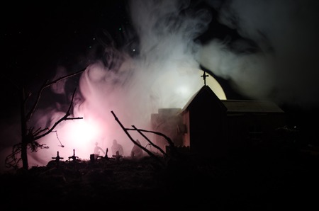 Scary view of zombies at cemetery dead tree, moon, church and spooky cloudy sky with fog, Horror Halloween concept. Tonedの写真素材
