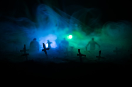 Silhouette of zombies walking over cemetery in night. Horror Halloween concept of group of zombies...