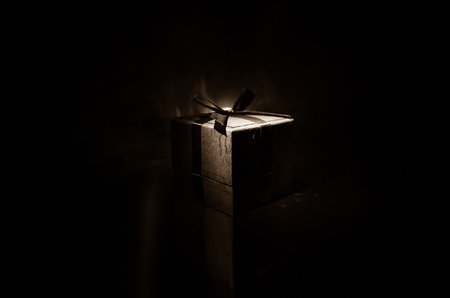 red gift box with red bow on dark toned background. Selective focusの写真素材