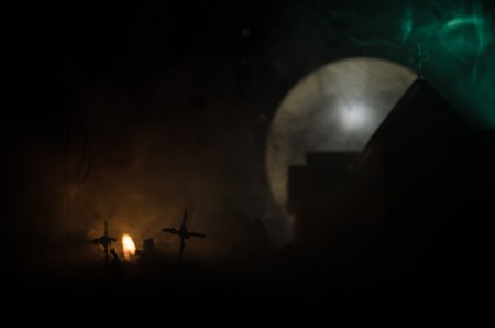 Scary view of zombies at cemetery dead tree, moon, church and spooky cloudy sky with fog, Horror...