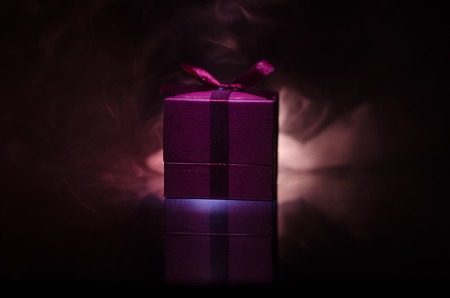 red gift box with red bow on dark toned background. Selective focusの写真素材