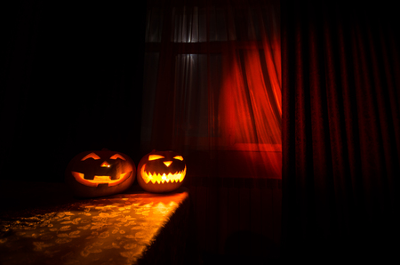 Scary Halloween pumpkin in the mystical house window at nightの写真素材